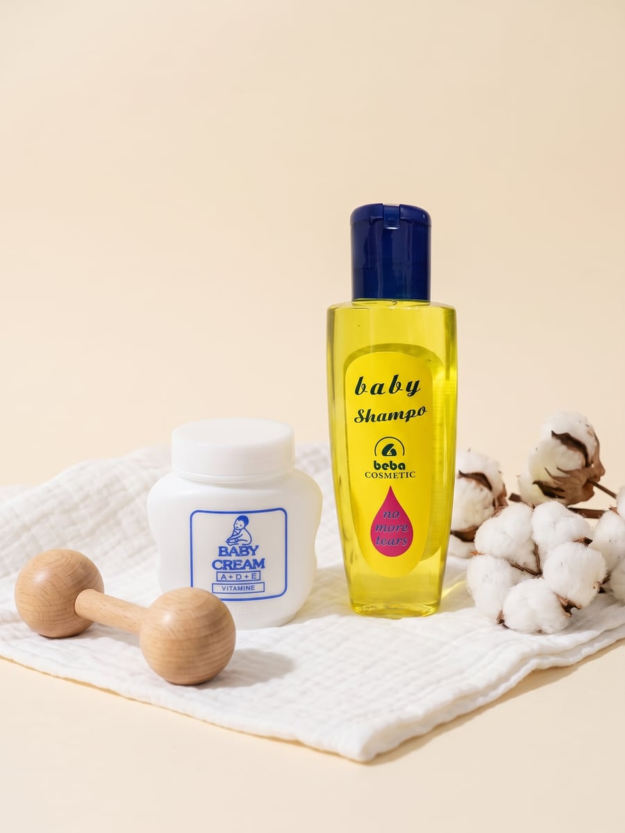 Shampo për bebe dhe Baby Cream A+D+E mbi një pëlhurë muslini, me një rrotkë druri